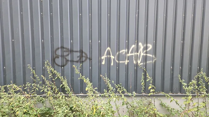 Schriftzug „ACAB“ auf einer Trapezblech-Fassade